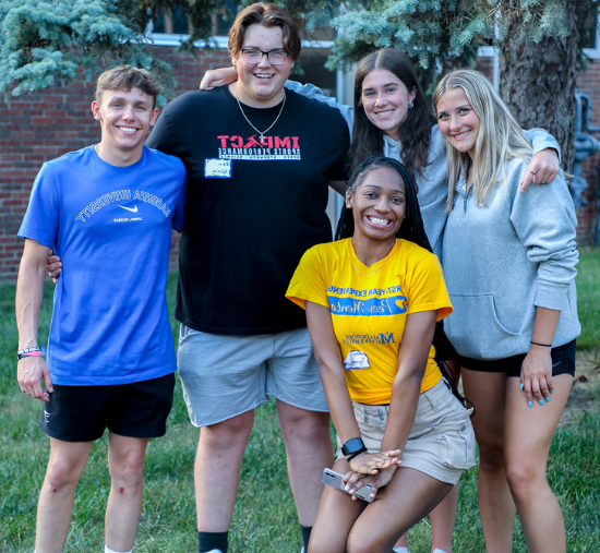 students smiling with peer mentor outside during new student orientation 2023